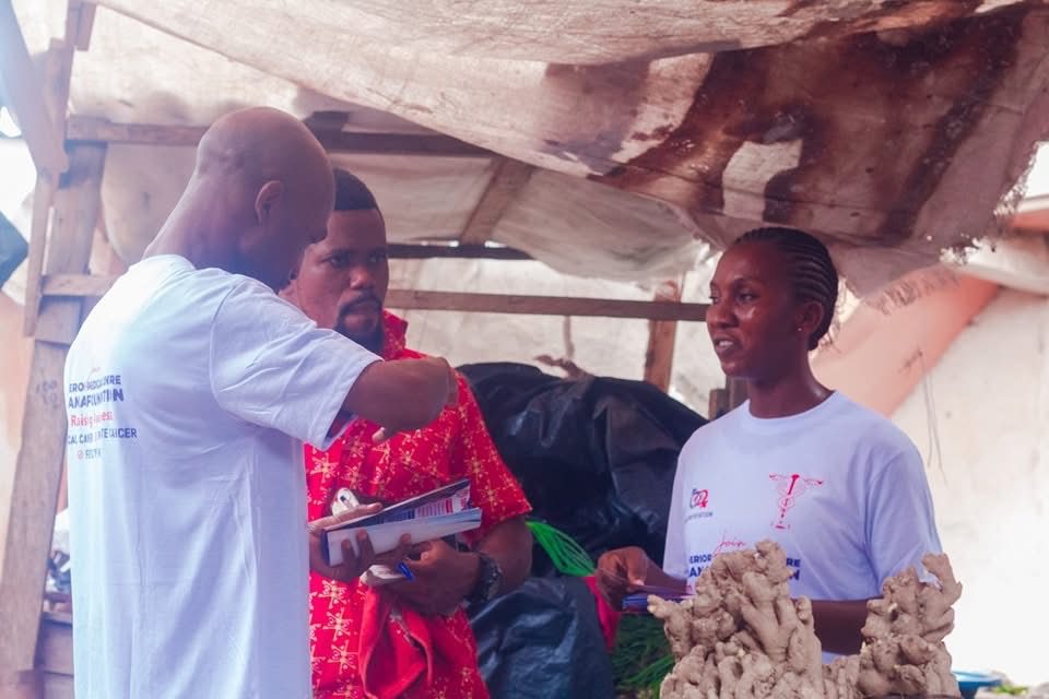 Jana Foundation handing awareness leaflets to a market vendor